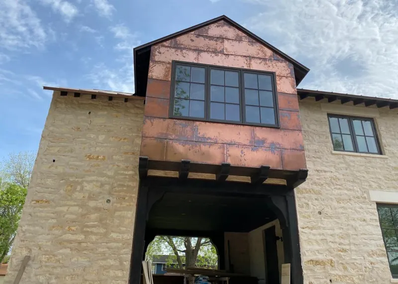Copper metal panel facade on a stone building for Skylight Installation in Mason City
